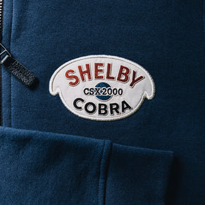 Photo of a Shelby Cobra embroidered patch for the original CSX2000 Cobra. This is embroidered onto the Red X Thread Luxe Bomber Sweater made of 100% cotton.