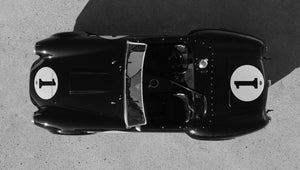 Top view of a Black Shelby Cobra race car with number 1 on a gray surface