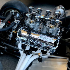 Close-up of a Shelby Cobra engine with visible branding on a blurred background