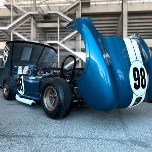 Blue Shelby Cobra race car with number 98 at a track