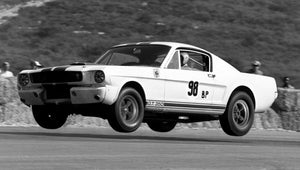Vintage black and white photo of a 1965 Shelby GT350 Mustang racing car on a track