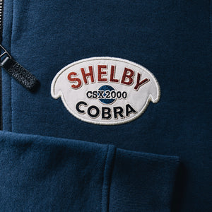 Photo of a Shelby Cobra embroidered patch for the original CSX2000 Cobra. This is embroidered onto the Red X Thread Luxe Bomber Sweater made of 100% cotton.